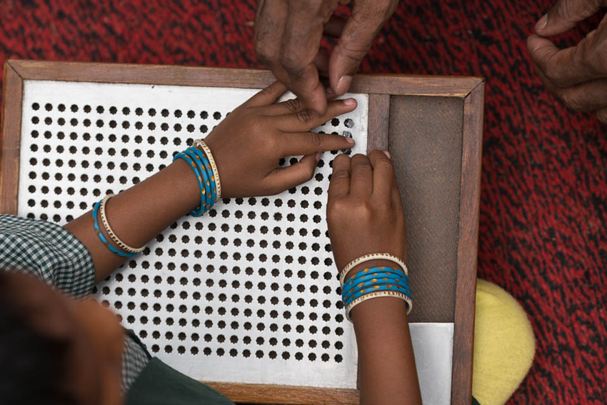 A young blind student learning to read braille, image by Gary Chapman. 