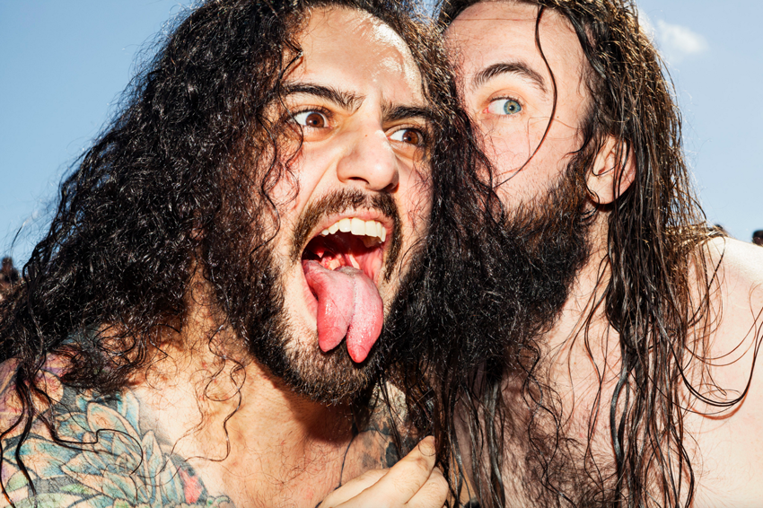 Two heavy metal fans, one sticking out his split tongue, pose for a photo by Giacomo Fortunato