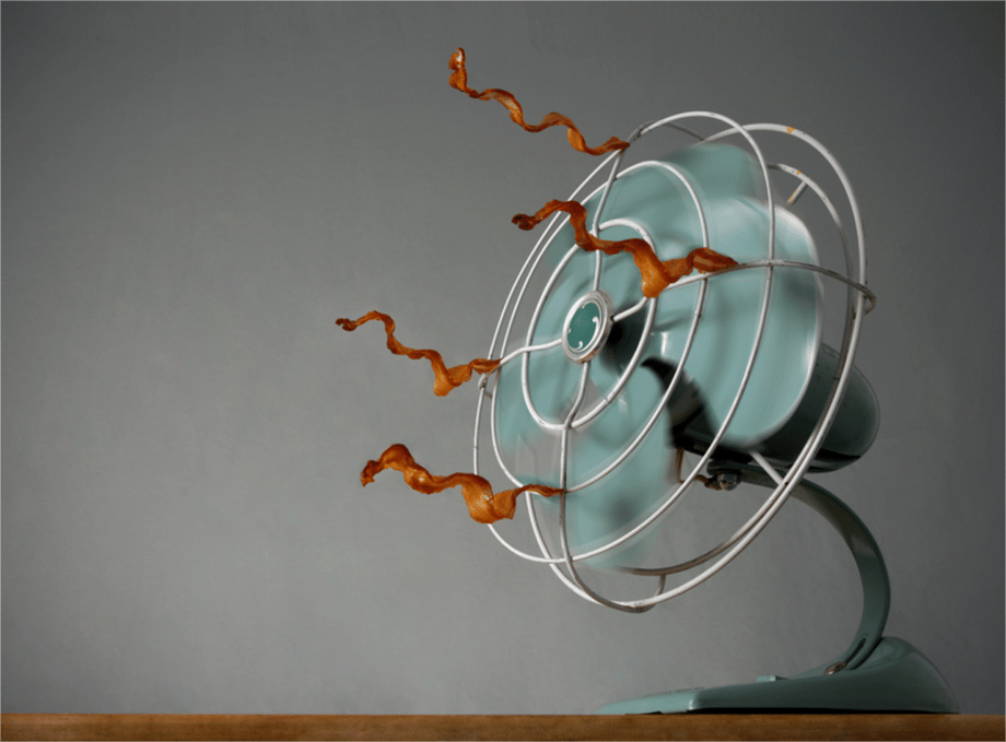 Photo by Hudson Stuart of a fan with bacon strips attached to it and blowing.