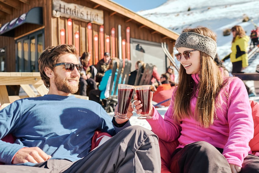 A couple drinking beer at a NZSki resort photographed by Jameson Clifton
