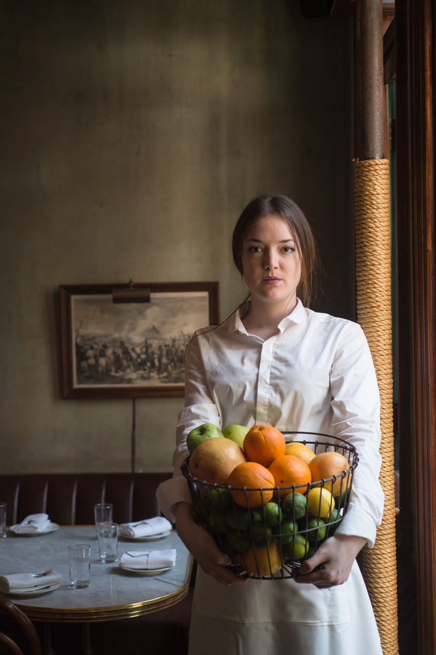 A chef holds a large bin of fruit in her arms, photo by Jennifer May.
