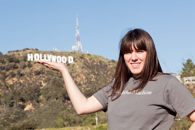 Maria holding the Hollywood sign with a Wonderful Machine t-shirt on
