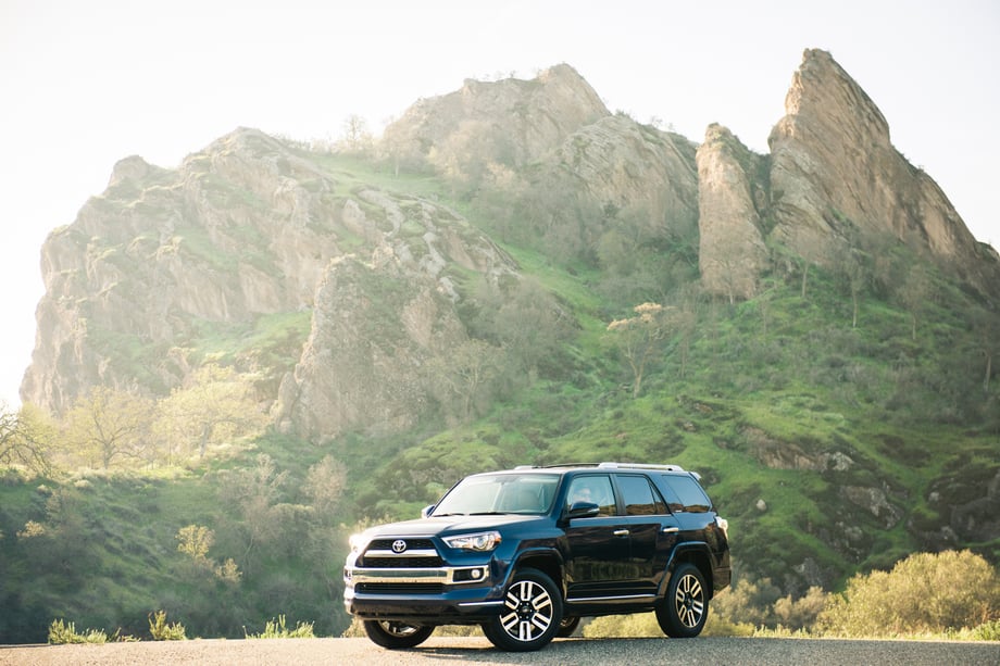 Toyota 4Runner parked in front of a beautiful, grassy rock structure, photo by Mark Skovorodko