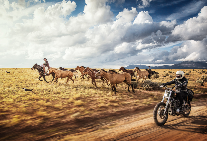 Photography by Michael Kunde of a cowboy with a herd of horses and a motorcyclist in Utah