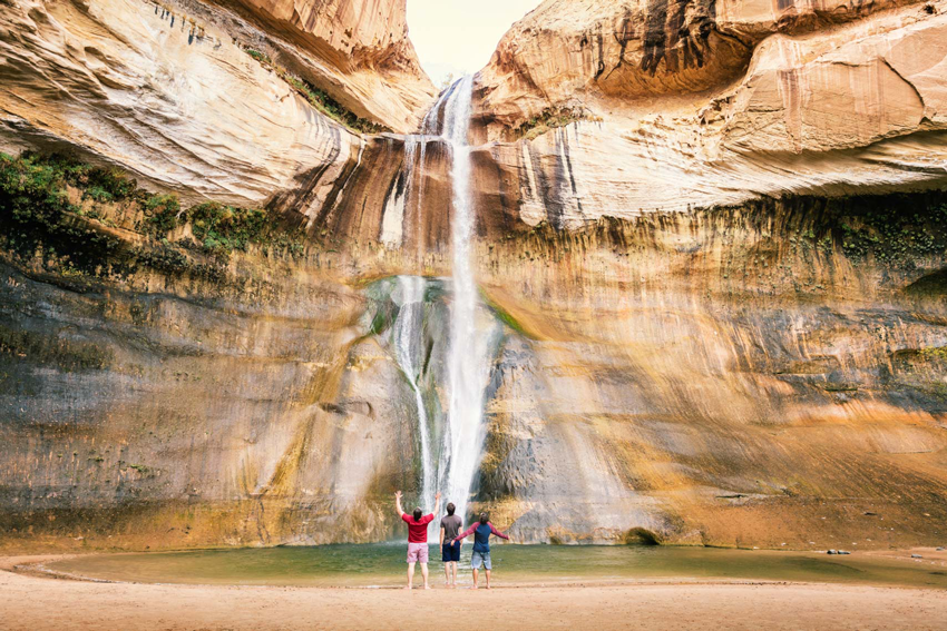 Photograph by Michael Kunde of friends facing a waterfall in Utah