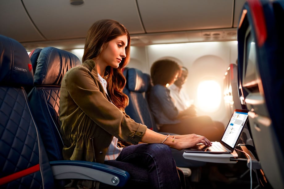 A young woman works on a laptop during her Delta flight as shot by John Fulton