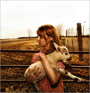 Photo of woman on a farm holding a lamb by Nikki Ormerod for Pikto Inc.
