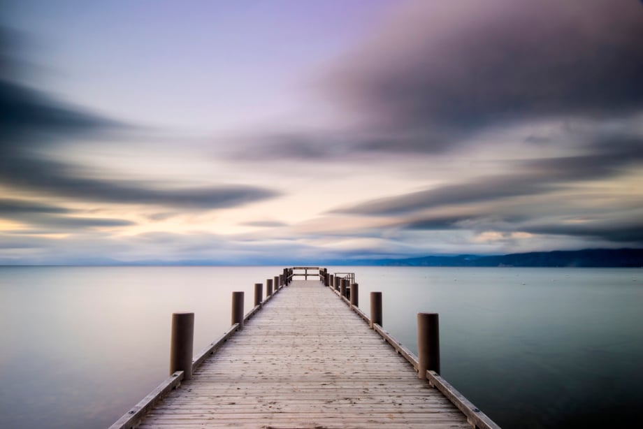 A pier heads off into the distance at dusk in Lake Tahoe, California.
