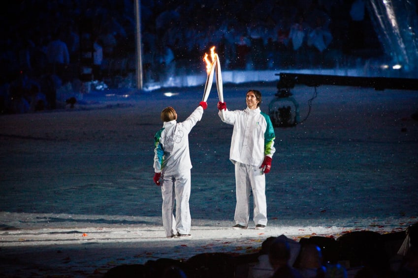 Two athletes holding torches in the Olympic ceremony shot by Roberto Muñoz.