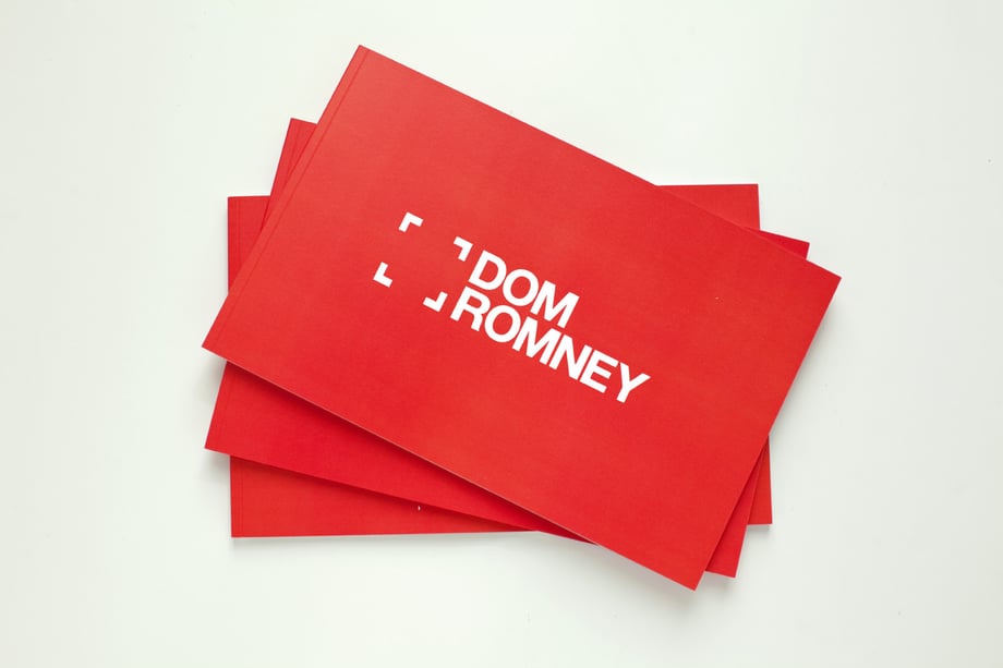 Dom Romney portfolio book stack
