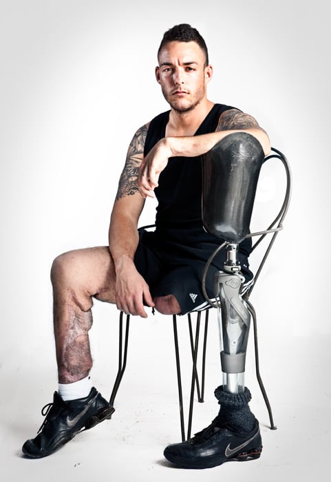 Spanish veteran holding his prosthetic leg shot by Madrid-based portrait photographer, James Rajotte for El Paris Semanal 