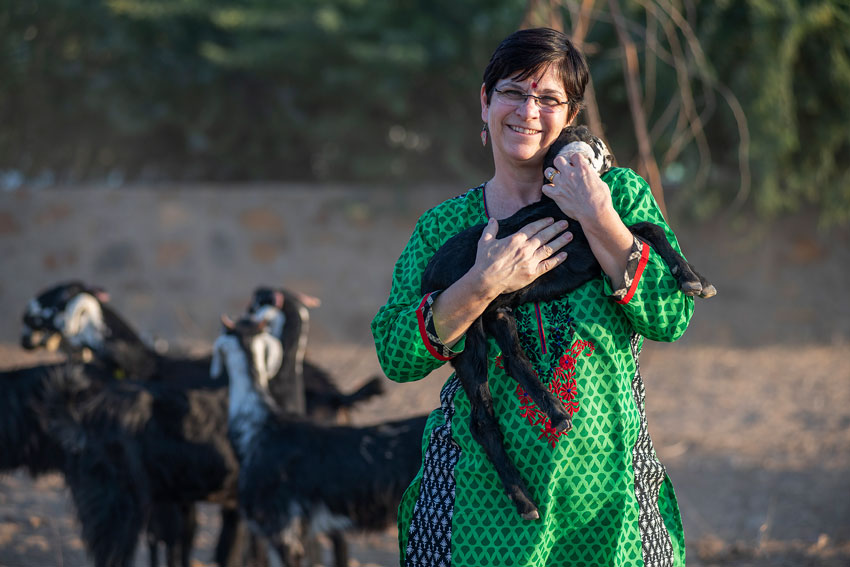 Photo by Sean Boggs of the Ninash Foundation's Linda Drake cradling a baby goat.