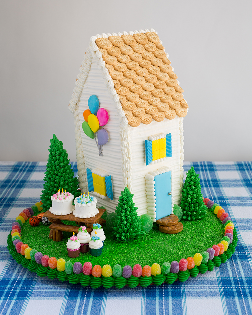 Photo of a gingerbread house on a circular, candied yard for book A Year of Gingerbread Houses by Kristine Samuell.