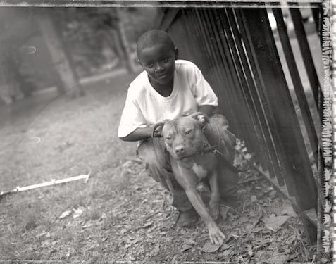 Photograph by Lou Bopp of a boy with a pit bull