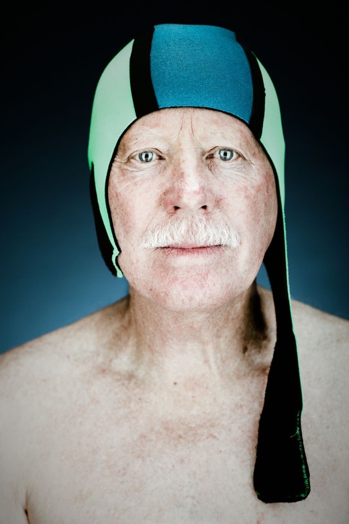 Portrait of an older male swimmer with a blue and green cap photographed by Vance Jacobs.