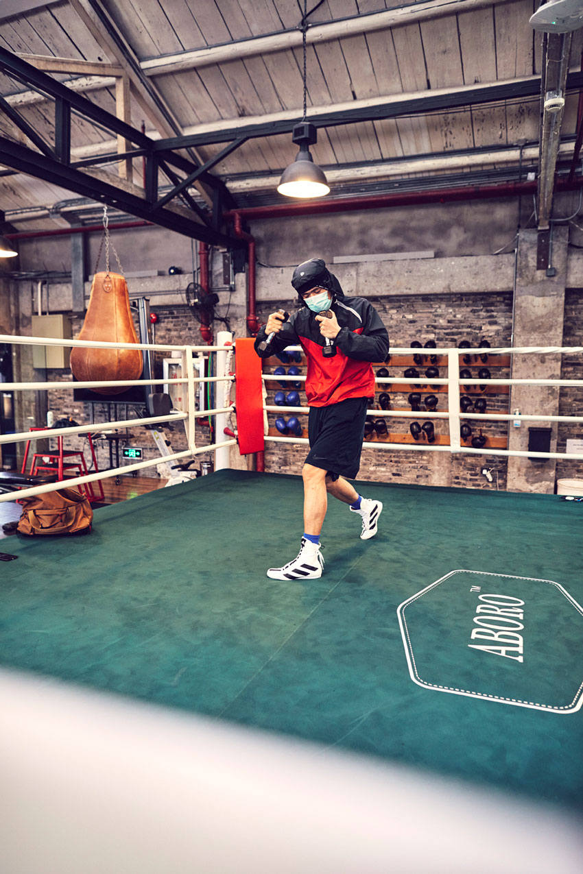 Photo of boxer practicing with weights in the ring.