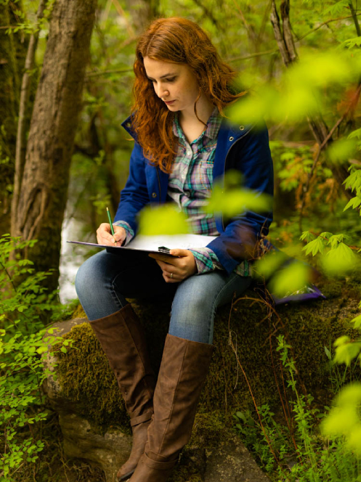 Woman drawing in a forested scene shot by Ed Sozhino for Case Knives