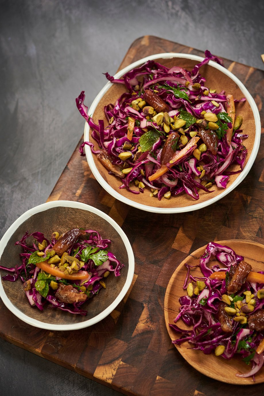 Dates and red cabbage in wooden bowls on top a wooden cutting block shot by Rebecca Peloquin for the Los Angeles Times