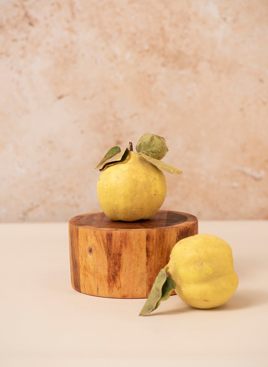 Yellow apples and their leaves arranged on a small wooden stump shot by Rebecca Peloquin for the Los Angeles Times