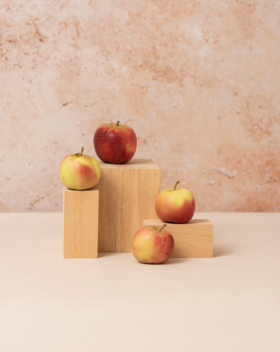 Four apples arranged on wooden blocks shot by Rebecca Peloquin for the Los Angeles Times