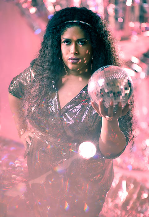 Fran Collazo holds a disco ball shot by Amy Rose Productions for Out and Out