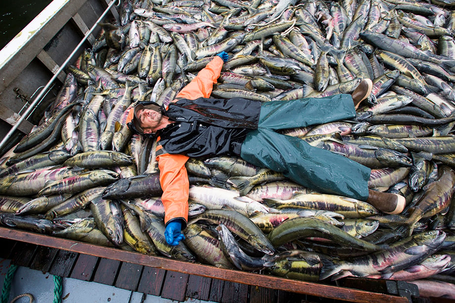Fisherman surrounded by fish. Photographed by Anya Chiblis.