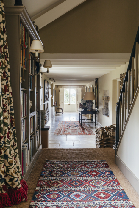 Interior shot of long hall featuring rugs, curtains, and art in Robert Carslaws Cornwall home shot by Anya Rice for Home & Garden magazine
