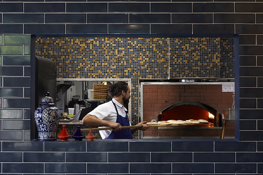 Chef pulling bread from brick oven in kitchen for Atlanta magazine 13 best restaurants shot by Bailey Garrot