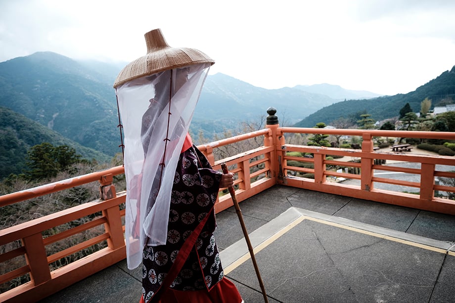 Saito Fumiko,  wearing Haein Ishyo at  Nachi Falls in Nachikatsuura, Wakayama Prefecture. Kumano Nachi Taisha Grand Shrine, Nachisan Seiganto-ji Temple and Nachi Waterfall The highlight of Wakayama tour is to visit the greatest / highest waterfall of JAPAN, Nachi Waterfall (133 m by one drop).Kumano Nachi Taisha Grand Shrine is one of the final destinations of Kumano Kodo(ancient routes). Nachi Waterfall is falling down divinely from the primeval forest.This is a stunning cultural landscape that reflects the strong traditional of Shinto-Buddhist syncretism. Text and photographs by Ben Weller.