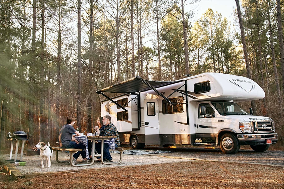 A family sits outside their RV while enjoying the outdoors shot by ben rollins