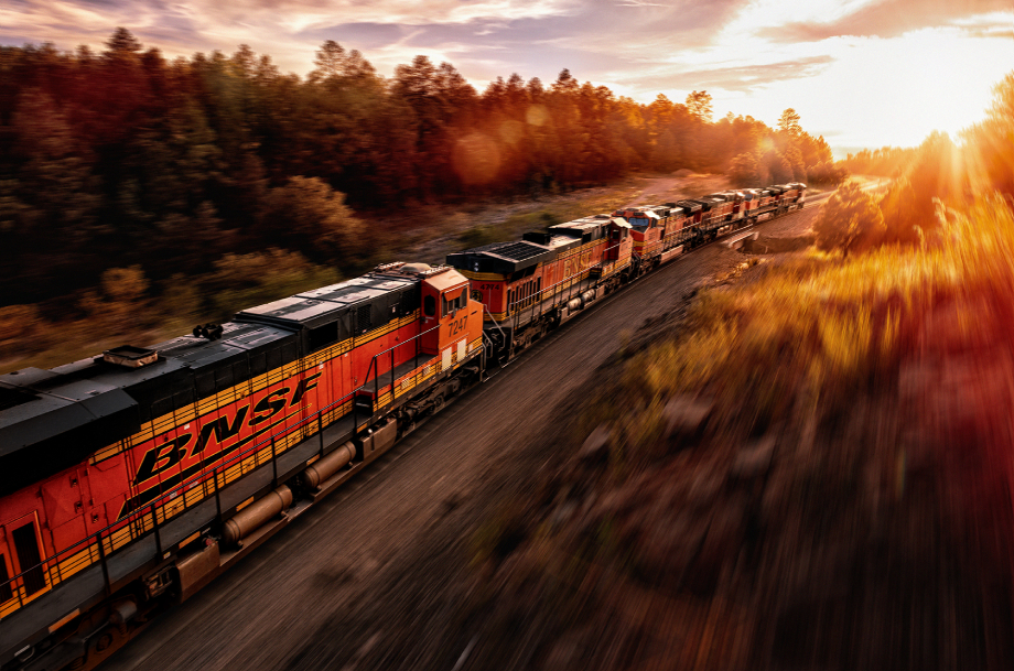 Freight train passing forests at sunset shot by Blair Bunting