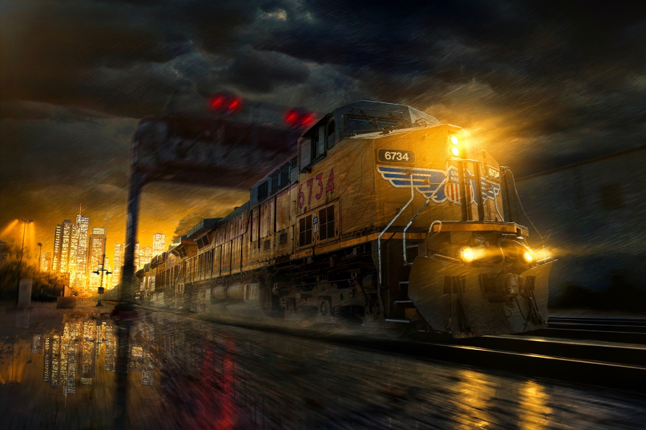 Freight train at night with city lights in background shot by Blair Bunting