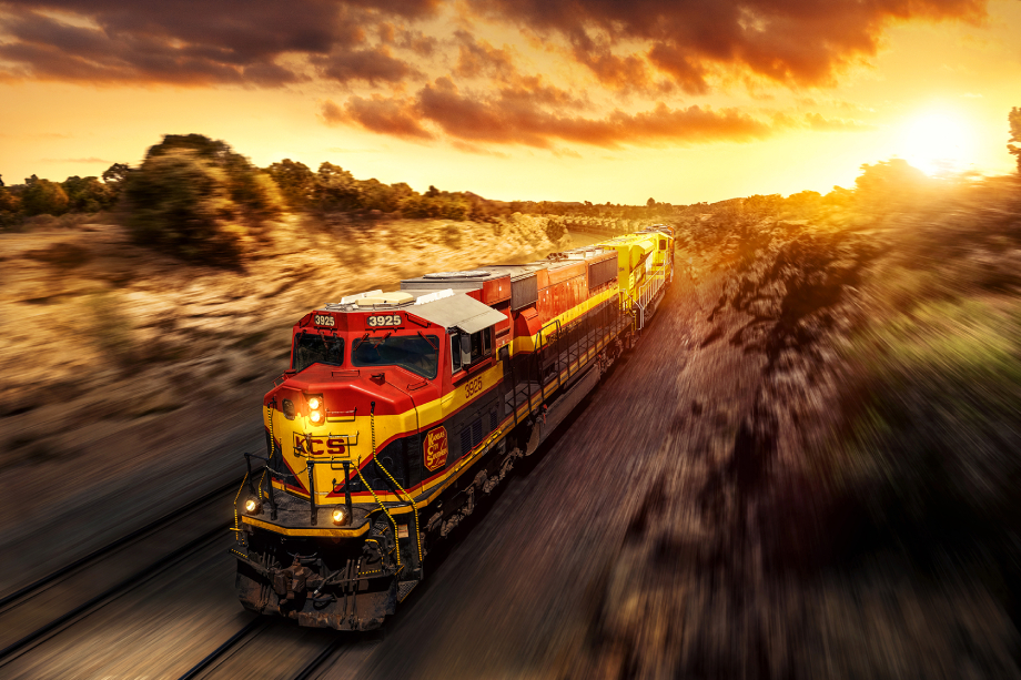 Freight train passing through desert landscape with an orange sky shot by Blair Bunting