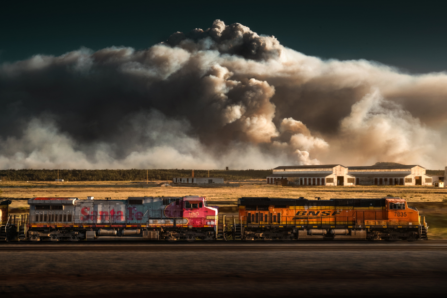 Freight train passing in front of giant cloud of wildfire smoke shot by Blair Bunting