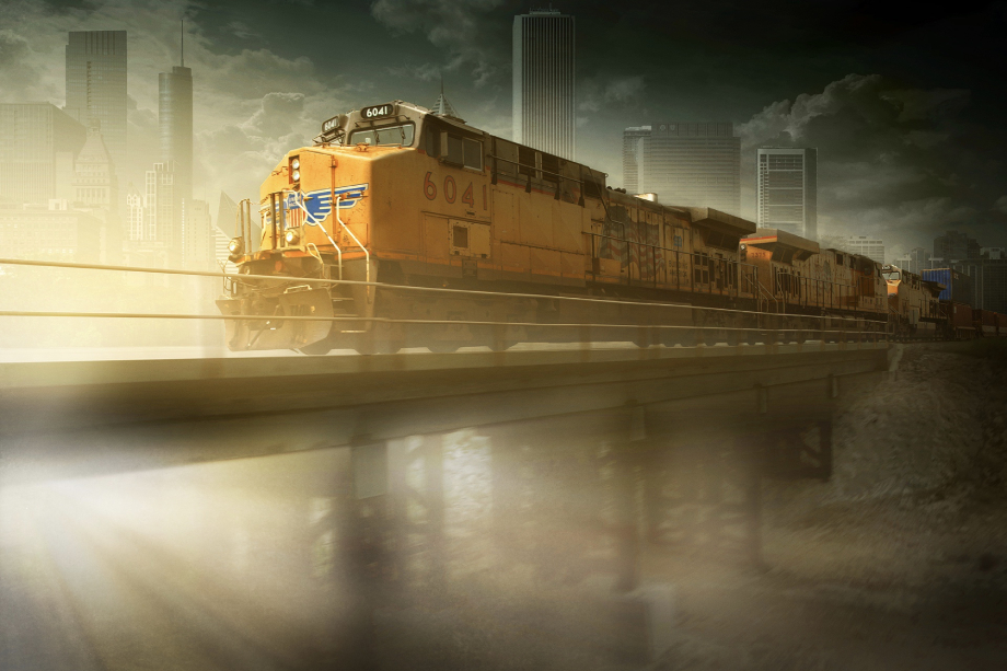 Freight train crossing bridge with city in background shot by Blair Bunting