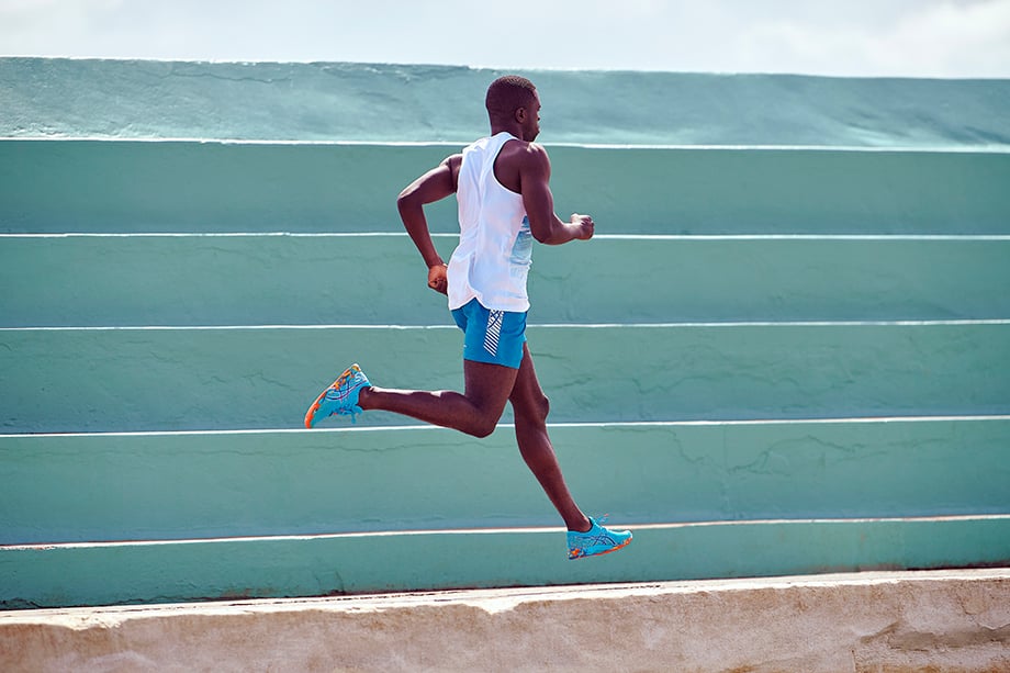 A runner jumps while wearing ASICS color injection sneakers for Brett Hemmings
