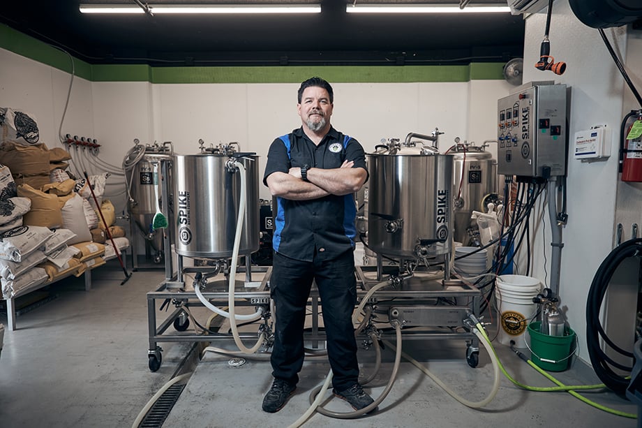 A brewer standing in front of his Spike brewing equipment. Photographed by CJ Foeckler for Spike Brewing. 