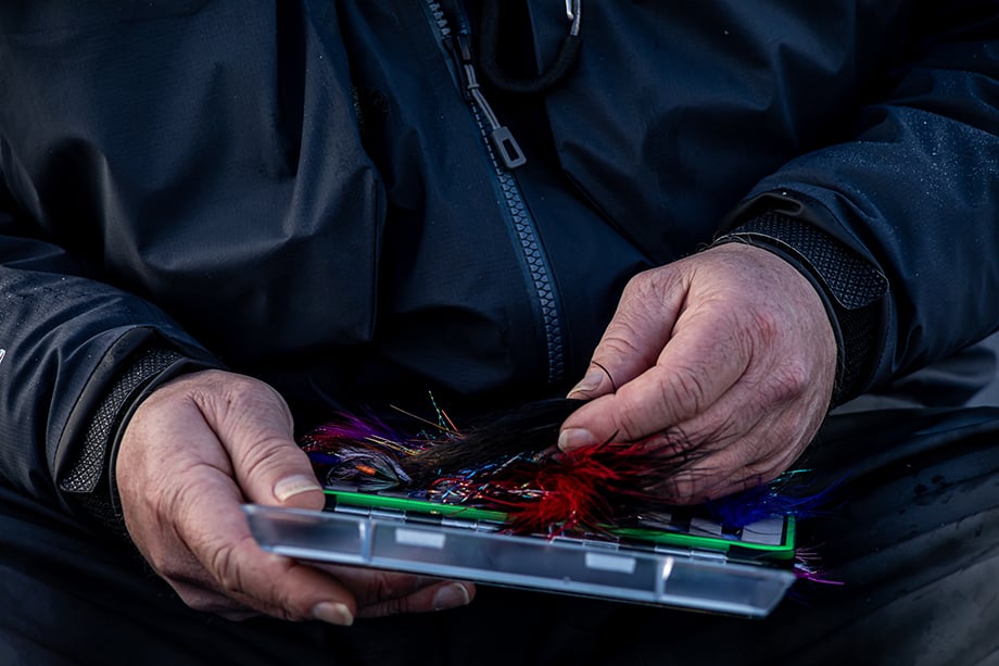 A fisherman holds a box with bait. Photographed by Cameron Karsten.