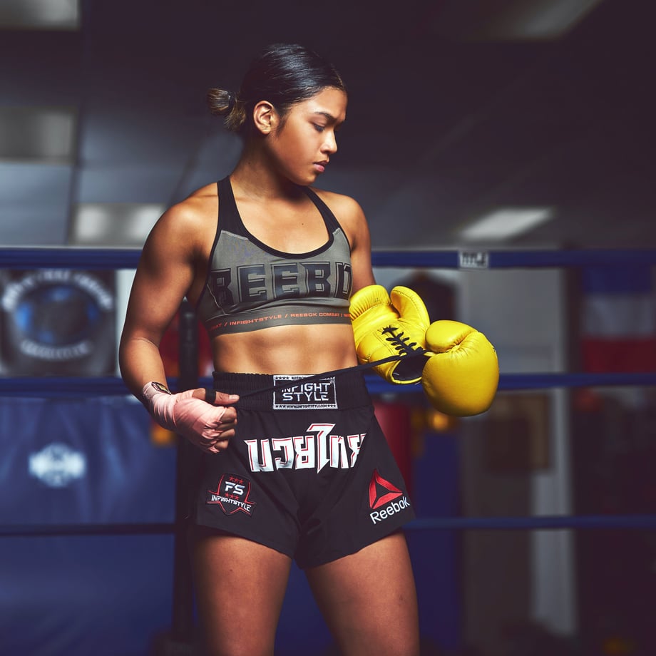 Jeff Dojillo's fighting portrait of Jackie Buntan as she peels her bright yellow gloves off wearing all Reebok and Infightstyle