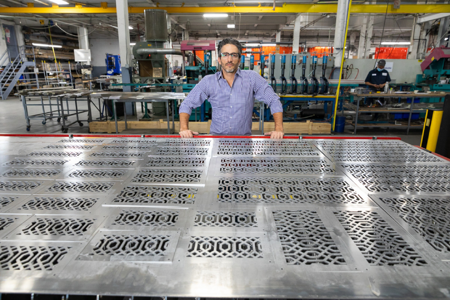 Worker standing with finished laser-cut metal shot by Dan Bigelow for Amada