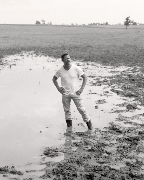 Film portrait of Steve Zahn standing in a muddy field shot by Egan Parks for the Hollywood Reporter