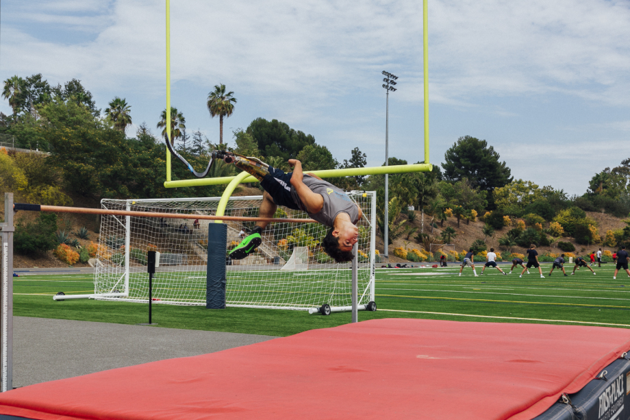 Ezra French jumps over the pole vault shot by Emily Malan for Teen Vogue