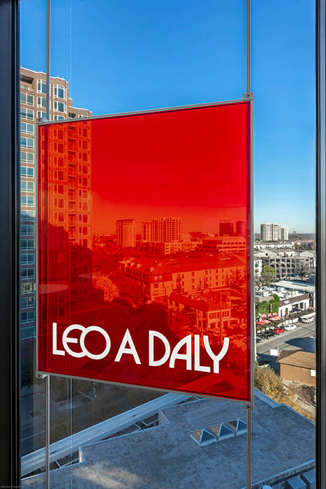 Close up of Leo A Daly's bright sign against the Dallas skyline. 