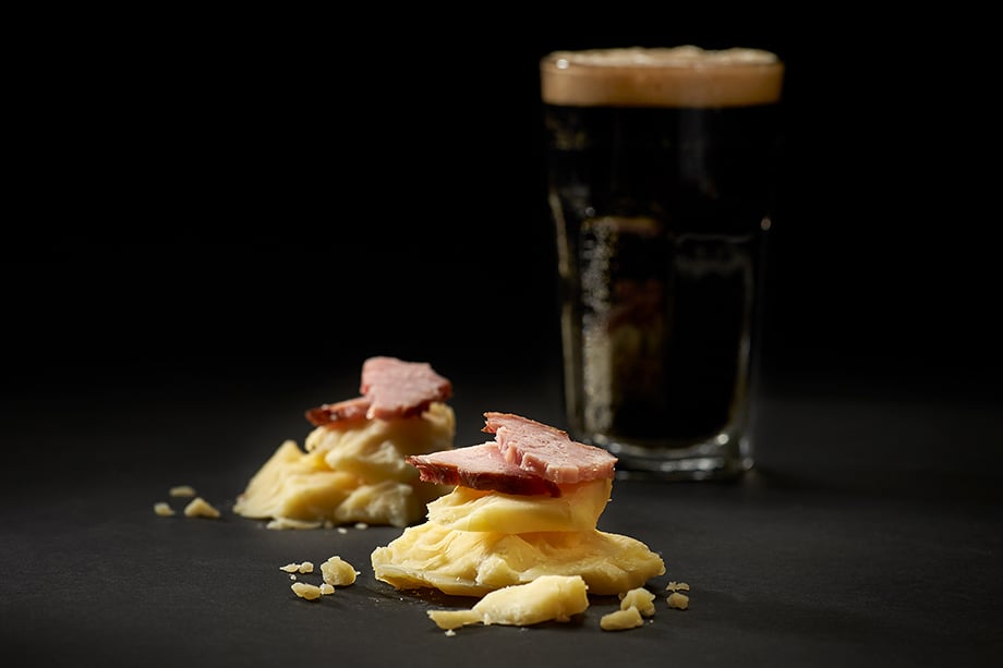 Closeup of cheese pairing with ham and beer. Photographed by John Valls for Tillamook Creamery. 