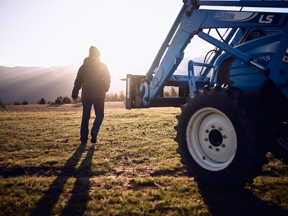 Amy next to a tractor on the ranch. Photography by Kody Kohlman