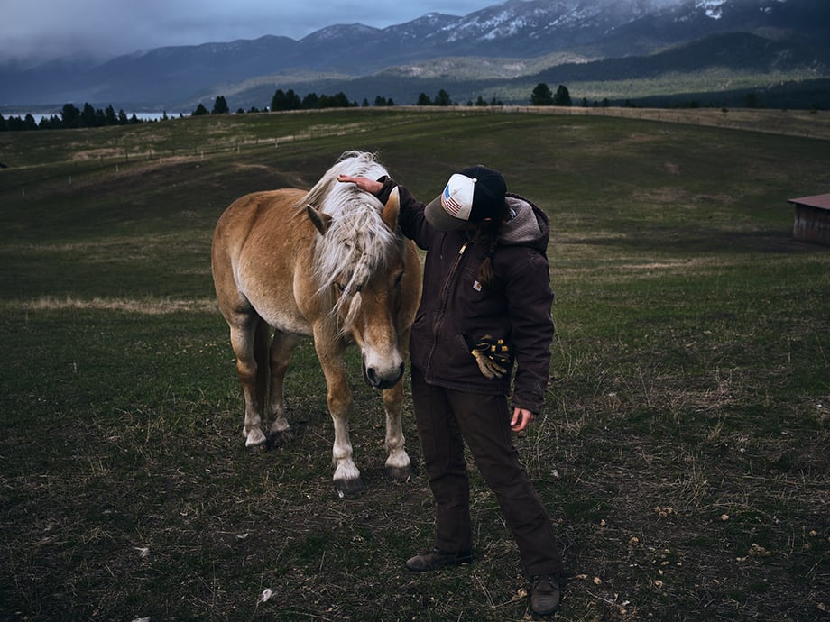Amy pets a horse. Photography by Kody Kohlman