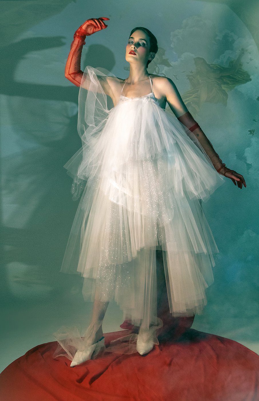 Model Amelia Pool wearing white layered toile dress and red gloves in front projected Renaissance art shot by Kirsten Miccoli