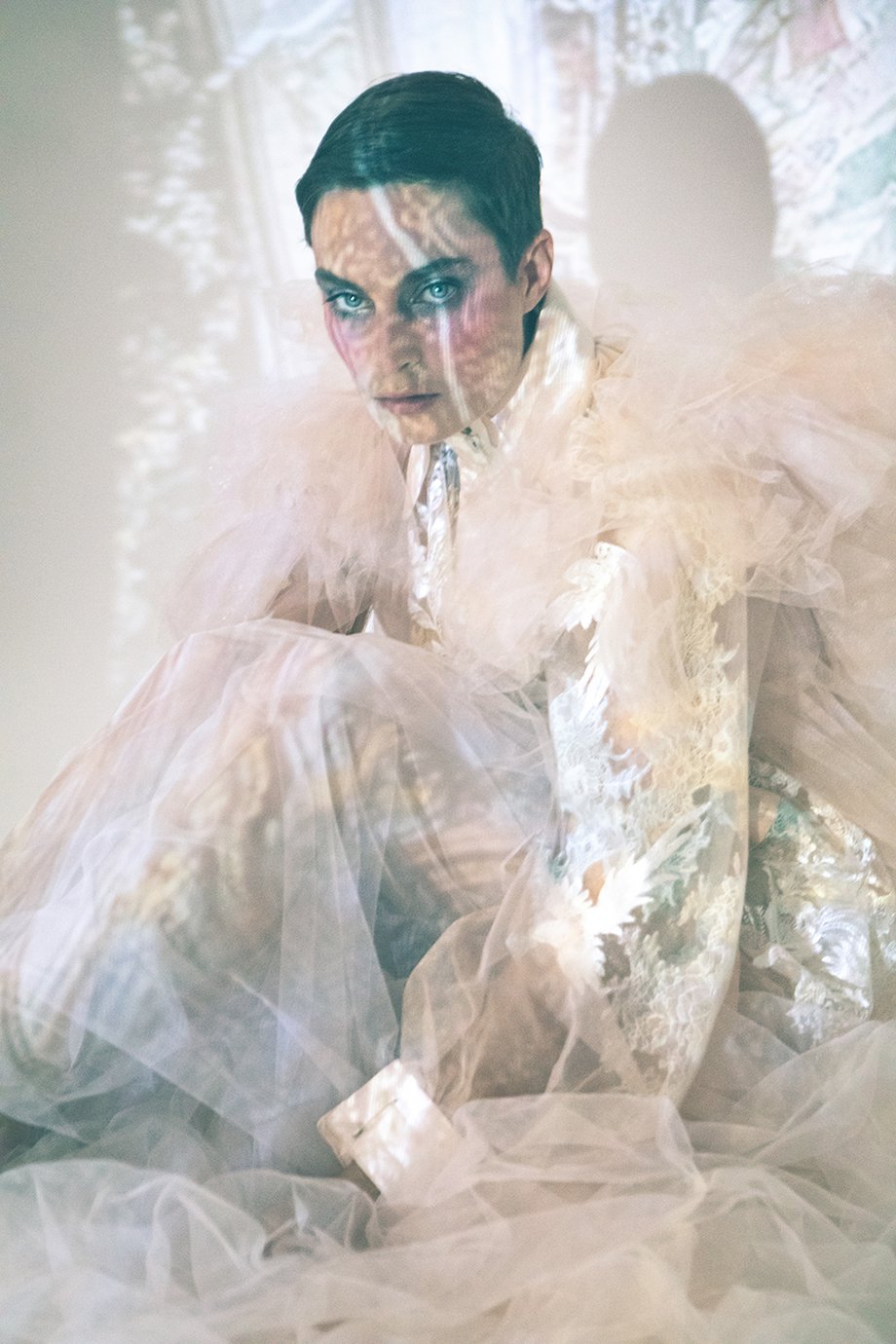 Model Amelia Pool lace and toile coat with projected Renaissance art lighting her face shot by Kirsten Miccoli