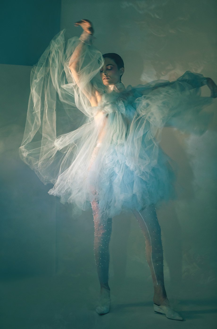 Model Amelia Pool moving her arms to dance with the toile of her blue dress shot by Kirsten Miccoli