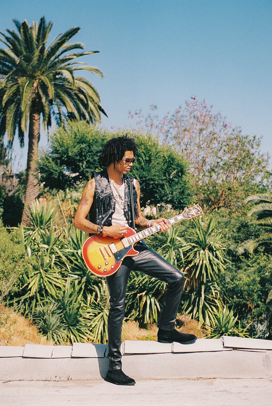 Model standing with electric guitar on roof shot on film by Michael Julius for New Republic Footwear Sonoma campaign